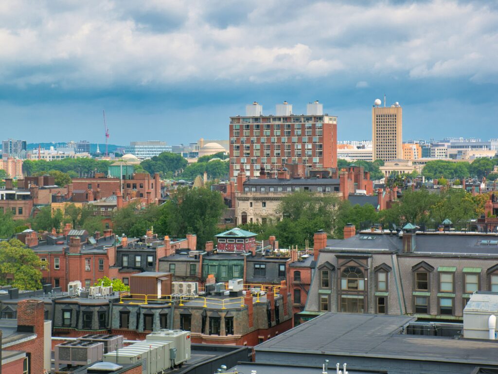 View of residential rooftops and low-rise buildings beneath a cloudy sky